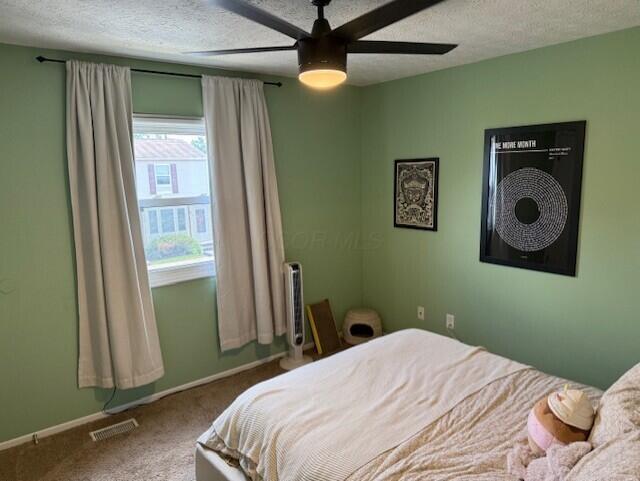 796 Cap Ln Unit 21C, Columbus, OH 43085 - carpeted bedroom featuring a textured ceiling and a ceiling fan