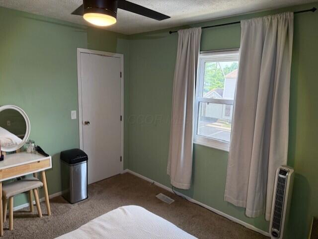 796 Cap Ln Unit 21C, Columbus, OH 43085 - bedroom featuring carpet floors, a textured ceiling, heating unit, and ceiling fan