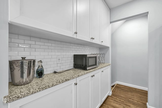 1533 Sandringham Ct, Columbus, OH 43220 - kitchen featuring stainless steel microwave, backsplash, white cabinetry, wood finished floors, and light stone countertops