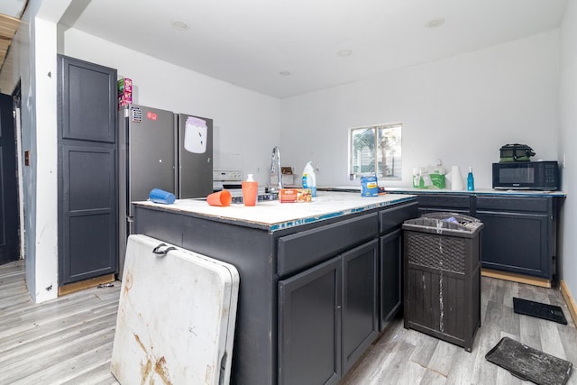 324 Quarry St, Marion, OH 43302 - kitchen with black microwave, light wood-type flooring, a center island, and light stone countertops
