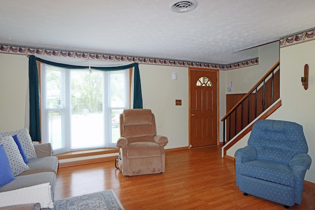 5278 Edgeview Rd, Columbus, OH 43207 - living room featuring wood finished floors, healthy amount of natural light, a textured ceiling, and stairway