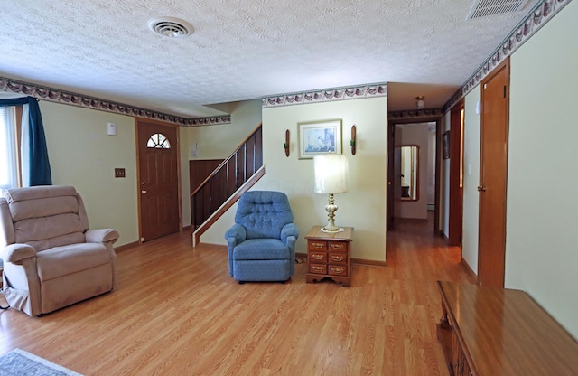 5278 Edgeview Rd, Columbus, OH 43207 - living area featuring light wood-style floors, stairway, and a textured ceiling