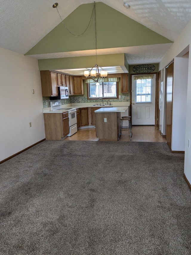 5813 Thada Ln, Columbus, OH 43229 - kitchen featuring white electric stove, vaulted ceiling, stainless steel microwave, light countertops, and light colored carpet