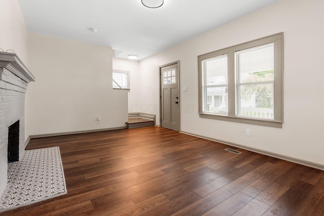 139 S Princeton Ave, Columbus, OH 43222 - unfurnished living room with wood finished floors and a brick fireplace