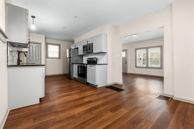 139 S Princeton Ave, Columbus, OH 43222 - kitchen featuring appliances with stainless steel finishes, dark countertops, dark wood-style floors, and backsplash