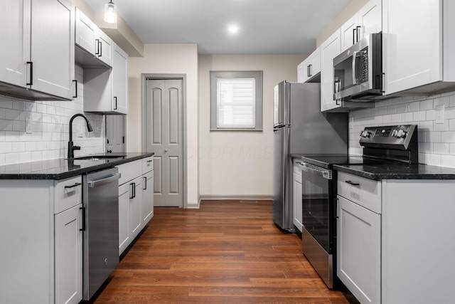 139 S Princeton Ave, Columbus, OH 43222 - kitchen with stainless steel appliances, dark wood-style floors, backsplash, and white cabinets
