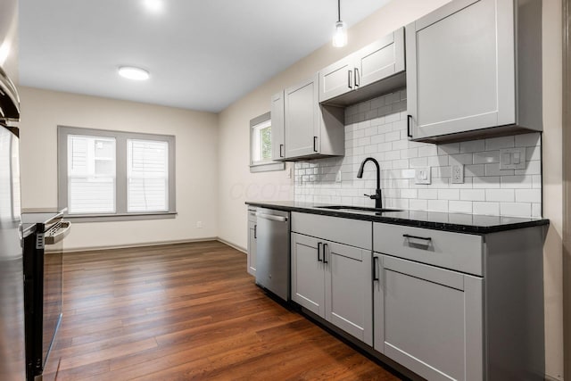139 S Princeton Ave, Columbus, OH 43222 - kitchen featuring stainless steel appliances, tasteful backsplash, dark wood-style flooring, dark stone countertops, and gray cabinets