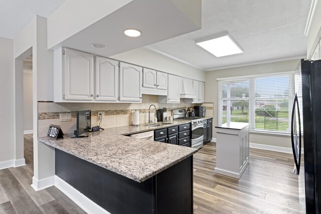 2635 Youngs Grove Rd, Columbus, OH 43231 - kitchen featuring stainless steel stove, freestanding refrigerator, white cabinetry, light wood-type flooring, and ornamental molding