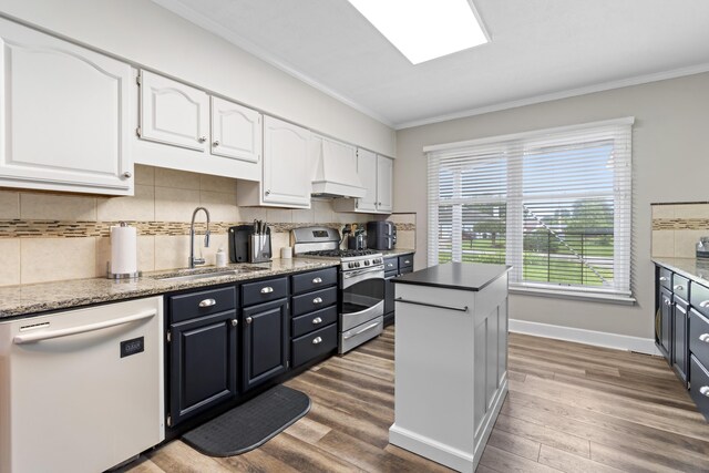 2635 Youngs Grove Rd, Columbus, OH 43231 - kitchen with white dishwasher, gas stove, white cabinetry, ornamental molding, and wood finished floors