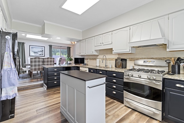 2635 Youngs Grove Rd, Columbus, OH 43231 - kitchen with gas range, fridge, white cabinets, custom exhaust hood, and ornamental molding