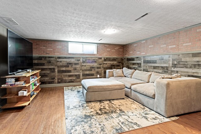2635 Youngs Grove Rd, Columbus, OH 43231 - living area with wood finished floors, brick wall, and a textured ceiling