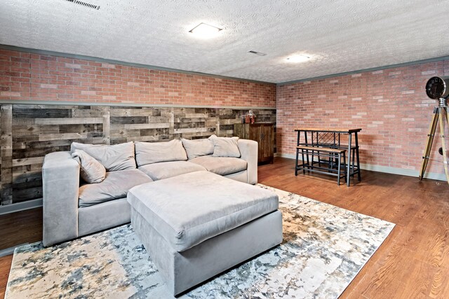2635 Youngs Grove Rd, Columbus, OH 43231 - living area featuring brick wall, wood finished floors, and a textured ceiling