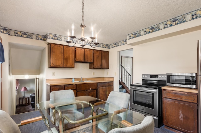 229 Danbury Rd, West Jefferson, OH 43162 - kitchen featuring appliances with stainless steel finishes, a chandelier, a textured ceiling, and pendant lighting
