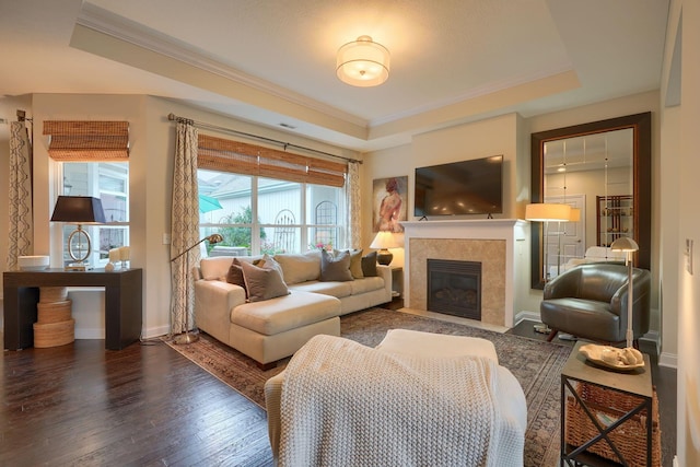 6918 Rothwell St, New Albany, OH 43054 - living area with a tray ceiling, dark wood-style floors, ornamental molding, and a fireplace
