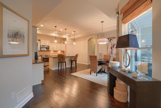 6918 Rothwell St, New Albany, OH 43054 - dining room with arched walkways, recessed lighting, dark wood-style flooring, and ornamental molding