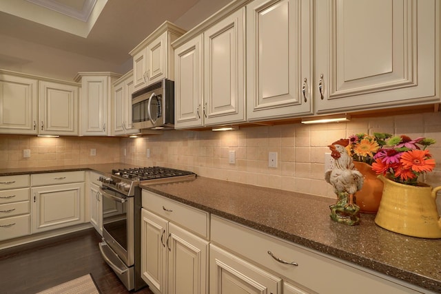 6918 Rothwell St, New Albany, OH 43054 - kitchen with appliances with stainless steel finishes, decorative backsplash, dark stone counters, and dark wood finished floors