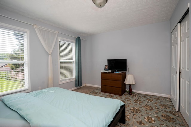 66 S Wheatland Ave, Columbus, OH 43204 - carpeted bedroom featuring a closet, multiple windows, and a textured ceiling
