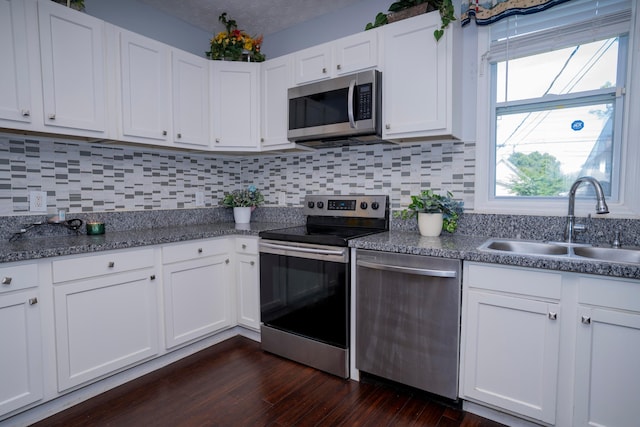 66 S Wheatland Ave, Columbus, OH 43204 - kitchen featuring stainless steel appliances, decorative backsplash, white cabinets, and dark wood-style flooring