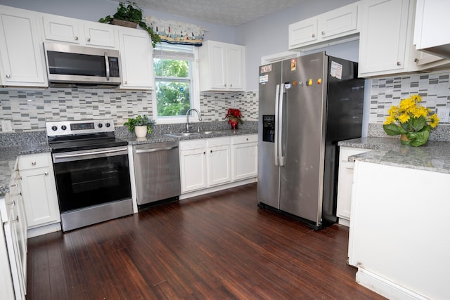 66 S Wheatland Ave, Columbus, OH 43204 - kitchen with appliances with stainless steel finishes, white cabinets, backsplash, and dark wood finished floors