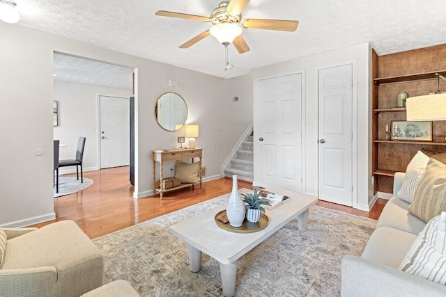 3155 El Greco Dr, Columbus, OH 43204 - living area featuring light wood-style flooring, a textured ceiling, ceiling fan, and stairway