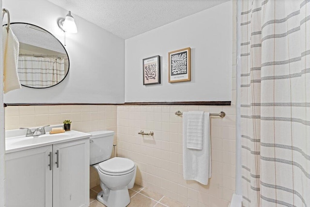 3155 El Greco Dr, Columbus, OH 43204 - full bath featuring vanity, tile patterned floors, tile walls, a textured ceiling, and wainscoting