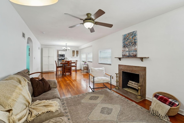1317 Broadview Ave, Columbus, OH 43212 - living area featuring arched walkways, ceiling fan, a chandelier, wood finished floors, and a fireplace