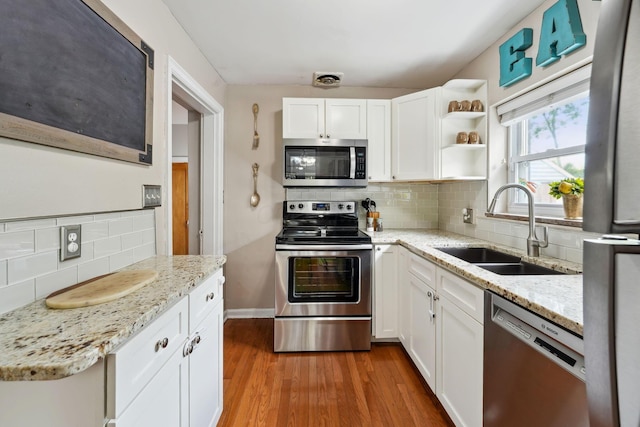 1317 Broadview Ave, Columbus, OH 43212 - kitchen with appliances with stainless steel finishes, tasteful backsplash, white cabinetry, and light wood-style flooring