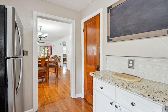 1317 Broadview Ave, Columbus, OH 43212 - kitchen with freestanding refrigerator, light wood-style flooring, decorative backsplash, white cabinetry, and light stone countertops