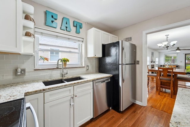 1317 Broadview Ave, Columbus, OH 43212 - kitchen with stainless steel appliances, a chandelier, white cabinets, hardwood / wood-style flooring, and tasteful backsplash