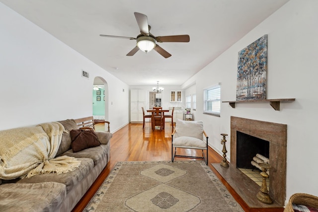 1317 Broadview Ave, Columbus, OH 43212 - living area featuring light wood-type flooring, ceiling fan, arched walkways, a chandelier, and a tile fireplace