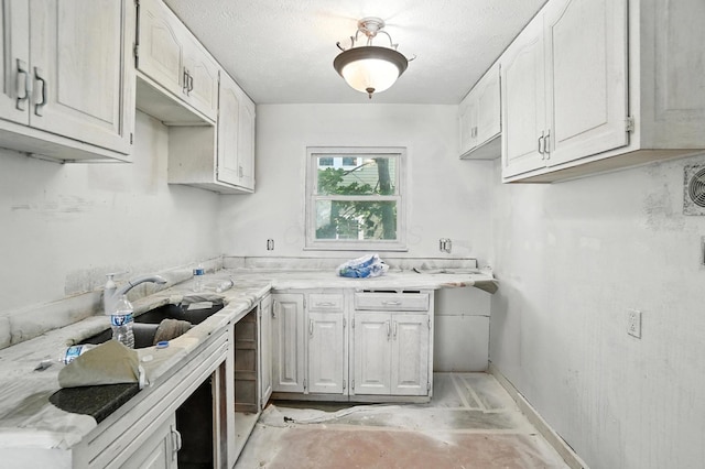 31 S Wheatland Ave, Columbus, OH 43204 - kitchen with light countertops, concrete floors, a textured ceiling, and white cabinetry