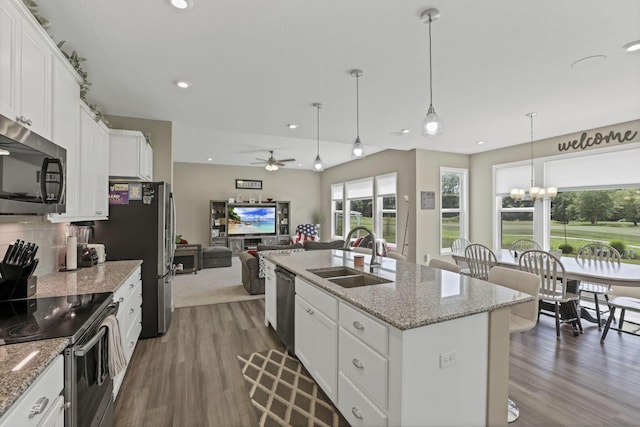 7250 Konold Ct, Canal Winchester, OH 43110 - kitchen with appliances with stainless steel finishes, wood finished floors, a ceiling fan, white cabinetry, and a kitchen island with sink