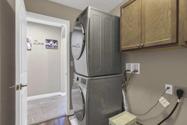 7250 Konold Ct, Canal Winchester, OH 43110 - washroom featuring cabinet space, stacked washing machine and dryer, and dark wood-style flooring