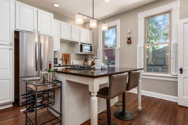 482 E Whittier St, Columbus, OH 43206 - kitchen with appliances with stainless steel finishes, white cabinetry, a breakfast bar, and recessed lighting