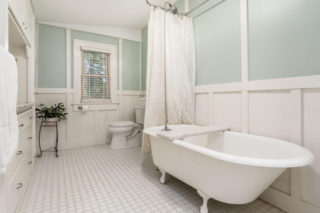 482 E Whittier St, Columbus, OH 43206 - full bath with a decorative wall, a soaking tub, a wainscoted wall, and tile patterned floors