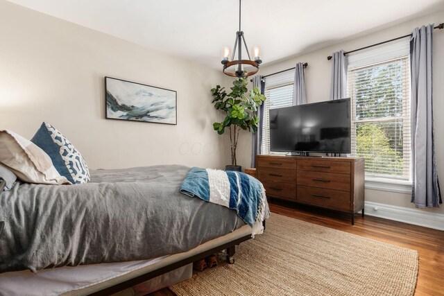 482 E Whittier St, Columbus, OH 43206 - bedroom featuring wood finished floors, a chandelier, and multiple windows