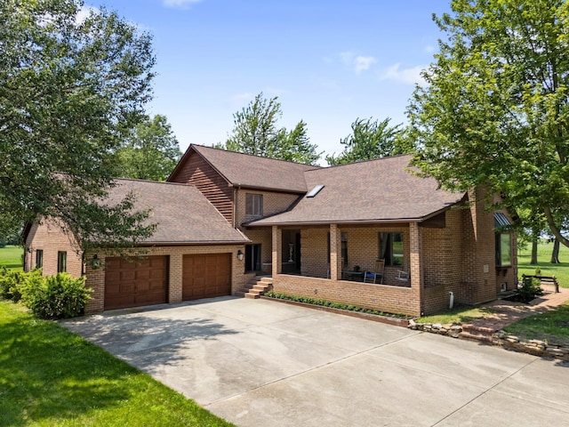 1178 London Rd, West Jefferson, OH 43162 - view of front of property with a porch, a garage, concrete driveway, and brick siding