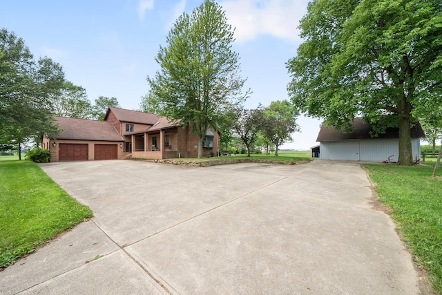 1178 London Rd, West Jefferson, OH 43162 - view of front of house featuring concrete driveway, a front lawn, a garage, and brick siding