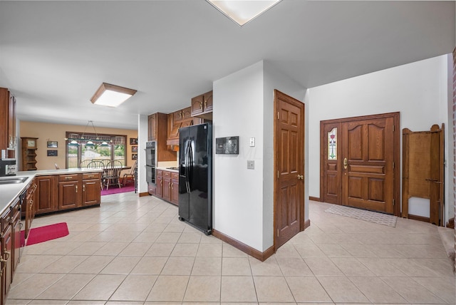 1178 London Rd, West Jefferson, OH 43162 - kitchen featuring black appliances, light tile patterned floors, light countertops, and a peninsula