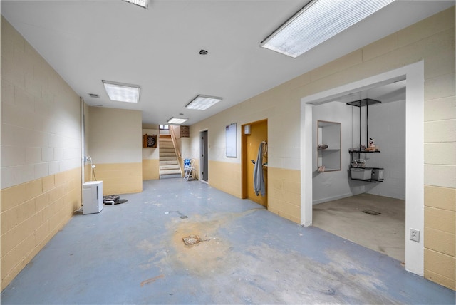 1178 London Rd, West Jefferson, OH 43162 - unfurnished room featuring concrete flooring, concrete block wall, and stairway