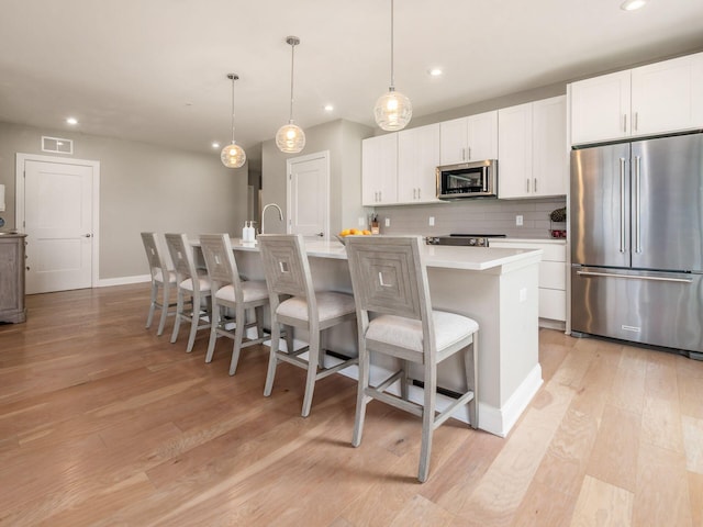 5285 Highpointe Lakes Dr Unit 201, Westerville, OH 43081 - kitchen featuring stainless steel appliances, recessed lighting, light wood-style flooring, a kitchen island with sink, and light countertops