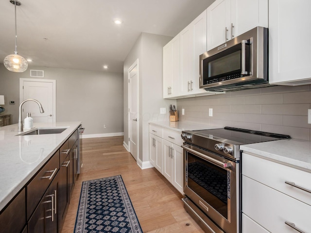 5285 Highpointe Lakes Dr Unit 201, Westerville, OH 43081 - kitchen with stainless steel appliances, decorative backsplash, white cabinetry, recessed lighting, and light wood finished floors