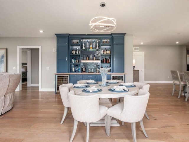 5285 Highpointe Lakes Dr Unit 201, Westerville, OH 43081 - dining area featuring beverage cooler, a dry bar, a chandelier, recessed lighting, and light wood-style floors