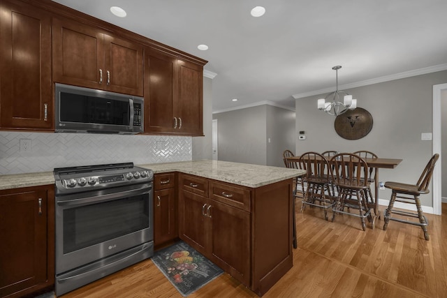 2579 Wickliffe Rd, Columbus, OH 43221 - kitchen featuring appliances with stainless steel finishes, light wood finished floors, backsplash, ornamental molding, and a peninsula
