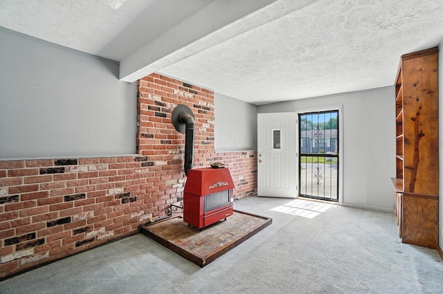 4143 Jonquil St, Columbus, OH 43224 - unfurnished living room with a wood stove, carpet floors, a textured ceiling, and brick wall