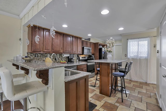 5276 Marci Way, Columbus, OH 43228 - kitchen featuring stainless steel appliances, ornamental molding, a kitchen bar, decorative backsplash, and light stone countertops