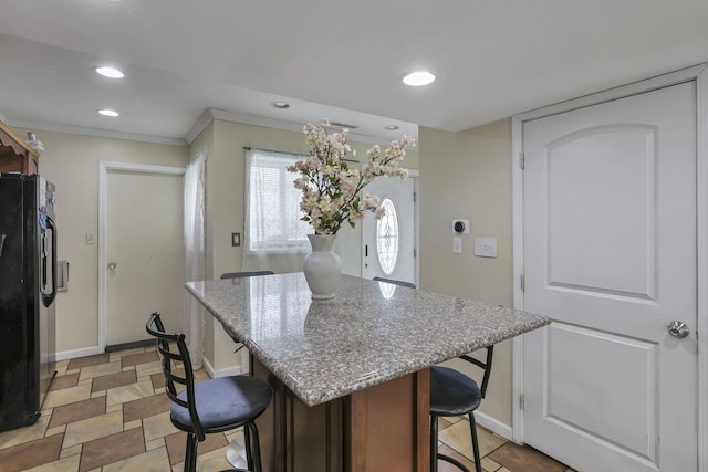5276 Marci Way, Columbus, OH 43228 - kitchen with black fridge with ice dispenser, a breakfast bar, a center island, recessed lighting, and light stone counters