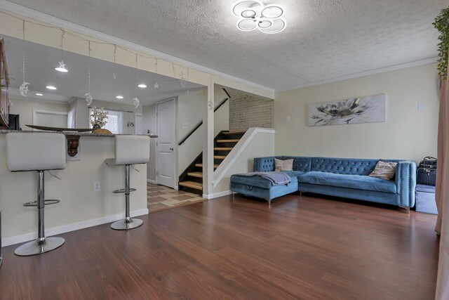 5276 Marci Way, Columbus, OH 43228 - living area featuring wood finished floors, stairway, a textured ceiling, and ornamental molding