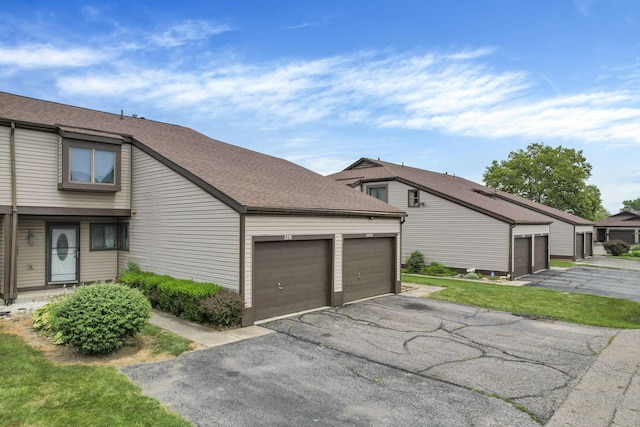 5276 Marci Way, Columbus, OH 43228 - view of side of home featuring a shingled roof and asphalt driveway