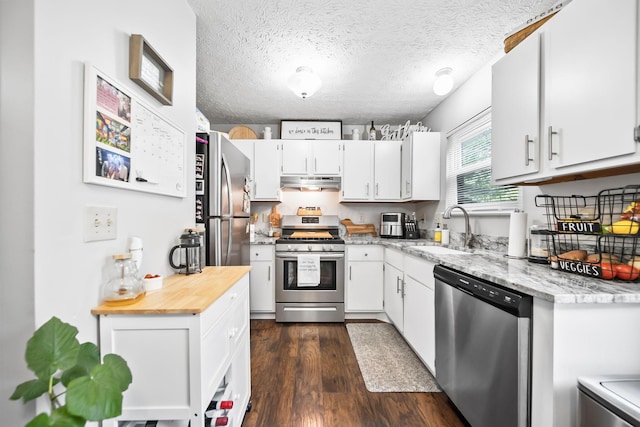 8194 Baltimore Ave Unit 6E, Westerville, OH 43081 - kitchen with stainless steel appliances, under cabinet range hood, dark wood finished floors, white cabinetry, and a textured ceiling